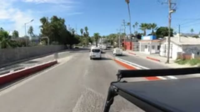 LOS CABOS MEXICO-2019: Vehicle Moves Down City Street Buildings On Side Of Road
