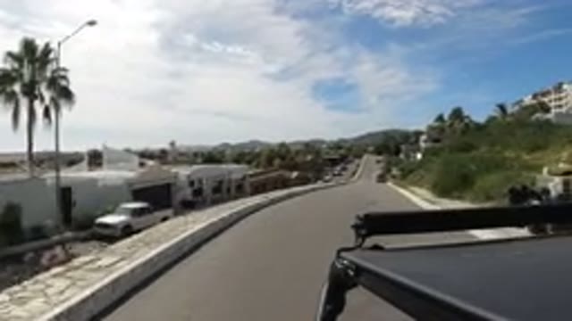 LOS CABOS MEXICO-2019: Car Driving Down A Road Through A Residential Area