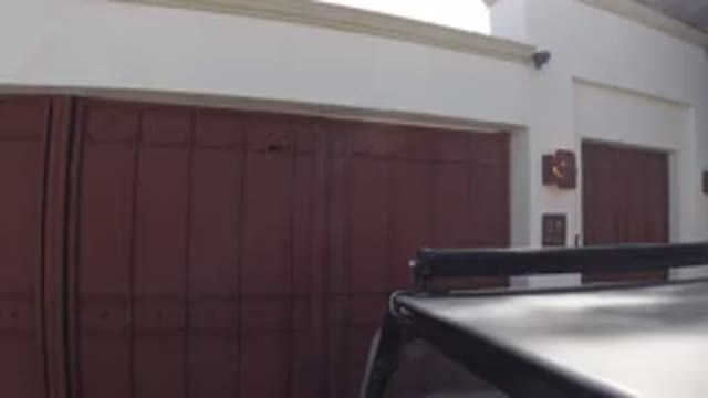 LOS CABOS MEXICO-2019: A Car In A Garage With A Red Gate And Tree Shadow