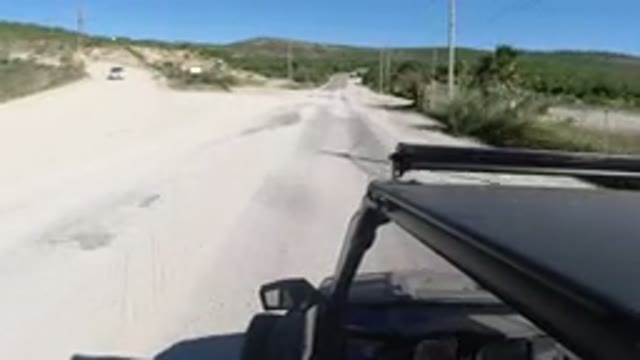 LOS CABOS MEXICO-2019: Mounted View Black Jeep Driving Down Dirt Road On