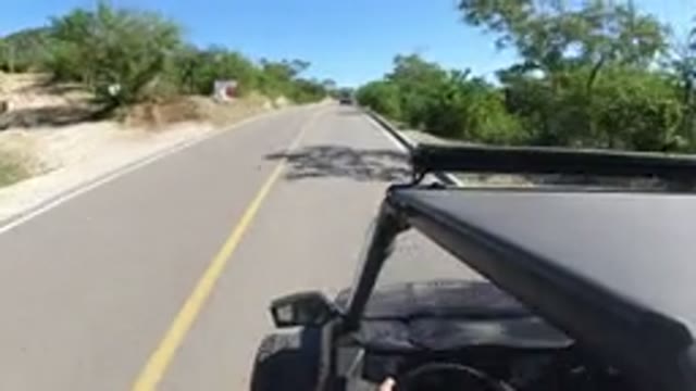 LOS CABOS MEXICO-2019: Black Car Zooms Down Road To Catch Car In Front