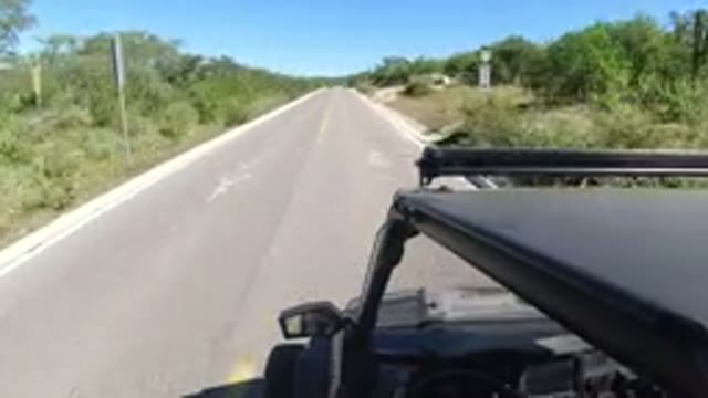 LOS CABOS MEXICO-2019: A Small Black Jeep Driving Fast Down An Empty Highway