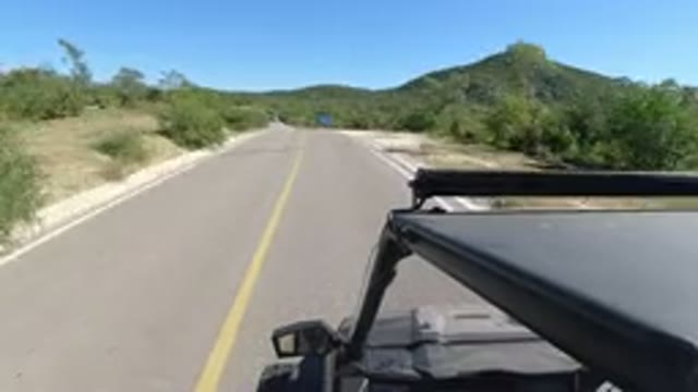 LOS CABOS MEXICO-2019: Fast-Driving Car On Two-Way Road With Trees Around