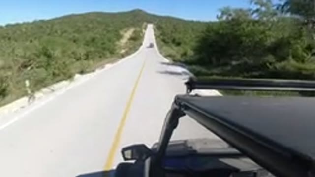 LOS CABOS MEXICO-2019: A Car Driving On A Long Two Lane Highway Through Rolling Hills