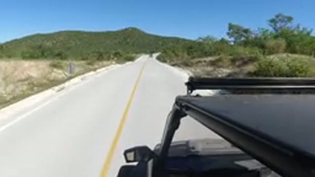 LOS CABOS MEXICO-2019: A Dark Colored Car Driving On A Long Road With A Large
