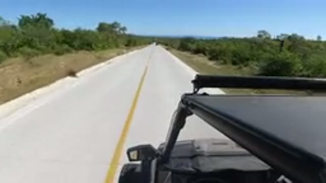 LOS CABOS MEXICO-2019: Jeep Cruising Down Empty Long Road On A Clear Sky Day