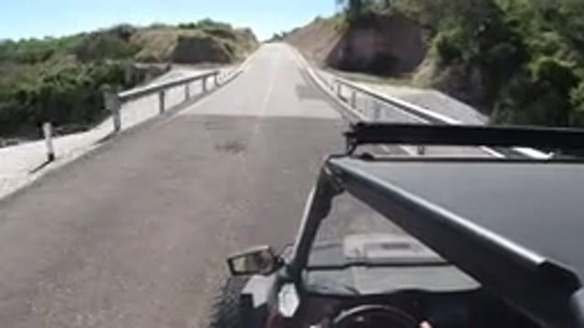 LOS CABOS MEXICO-2019: A Fast Moving Car Passing Over A Bridge With Hills On