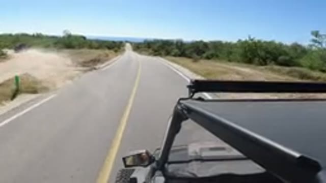 LOS CABOS MEXICO-2019: Black Car Driving In The Nature With Some Trees By The