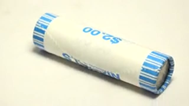 A Round Tube Like Item With White And Small Blue Stripes With Written Two Dollar