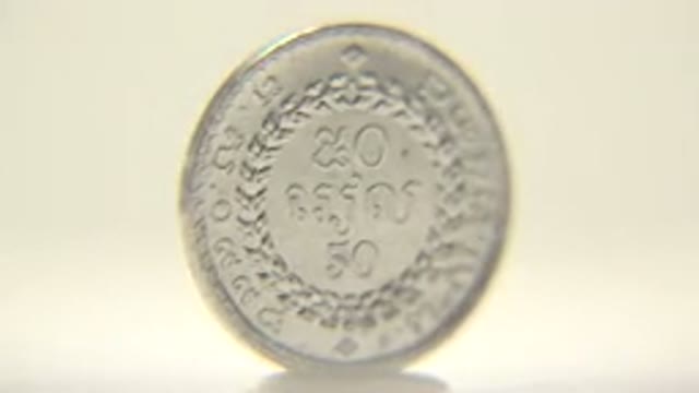 Shiny Silver Coin In Rotation With A Statue On One Side And Sign On Other