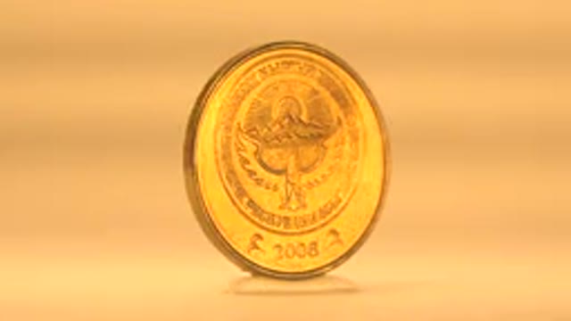 Spinning Gold Coin On Display Against Yellow Background