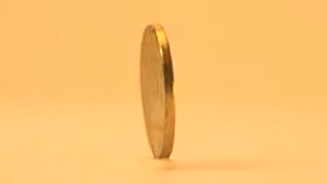 Rotating Golden Coin On A Flat Surface