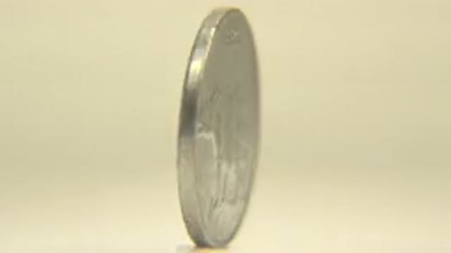 A Coin Is Rotating In Silver Color