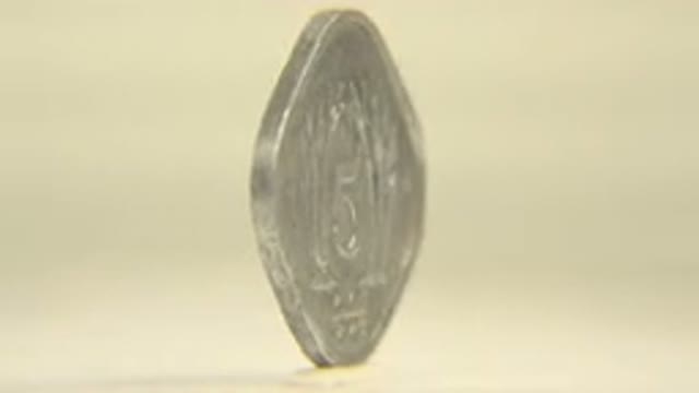 Spinning Circular Coin Inscribed With Arabic Script Moon Number Five And A Date
