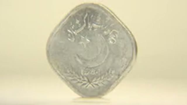 Silver Coin With Arabic Writing And A Large Slowly Pining On A Cream Background