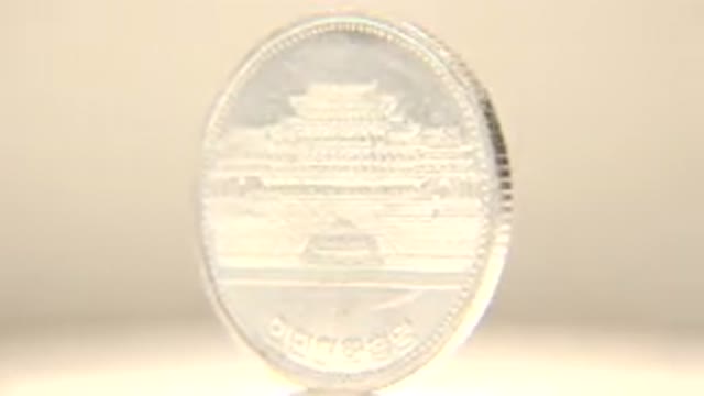 Spinning Silver Coin With Korean Writing On It