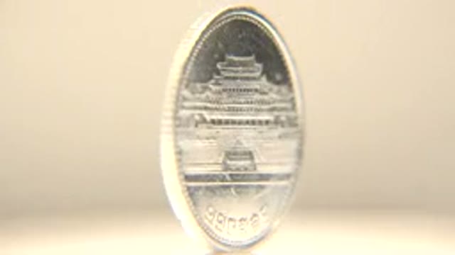 Metal Coin With Foreign Lettering Spinning On Its Side