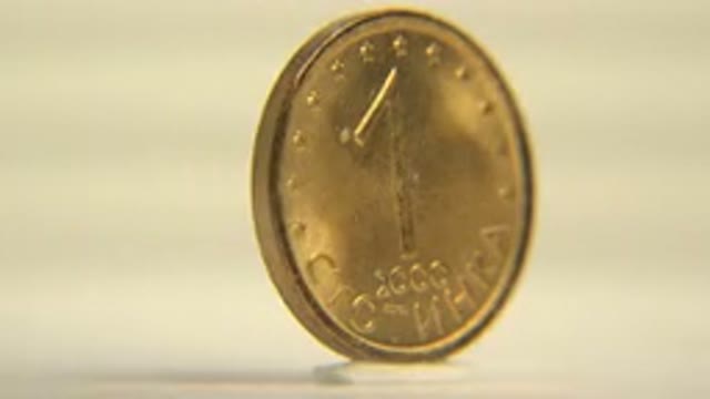Coin Rotating On A Spinning Platform With Lights Hitting On The Coin