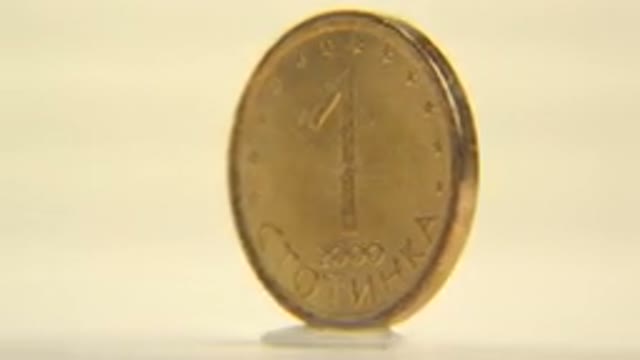 Coin On A Rotating Platform With Lights Hitting The Coin