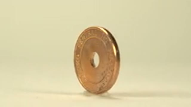 A Gold Coin Spinning Slowly Around On One Edge