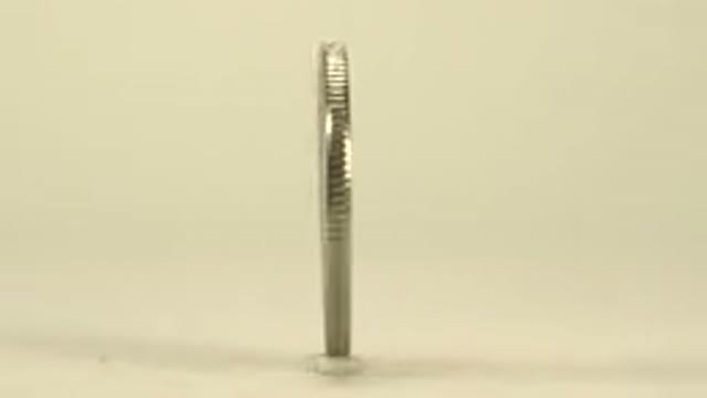 A Small Coin Being Spun In A Clockwise Motion To Show Off Both Sides Of It