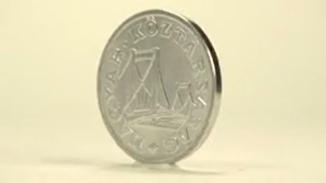 Shiny Spinning Engraved Silver Coin On Display For Commercial