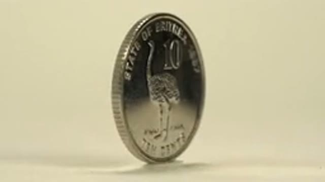 Coin On A Rotating Platform That Is Shining As The Light Hits The Coin