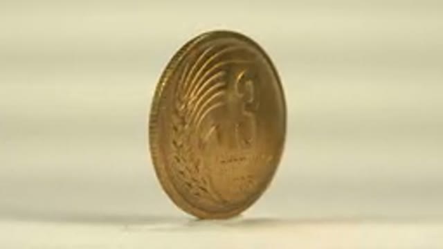 A Golden Coin With Cyrillic Letters And The Number Keeps Rotating