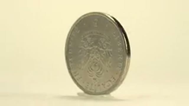 A Silver Haitian Coin From Spins Around On Display