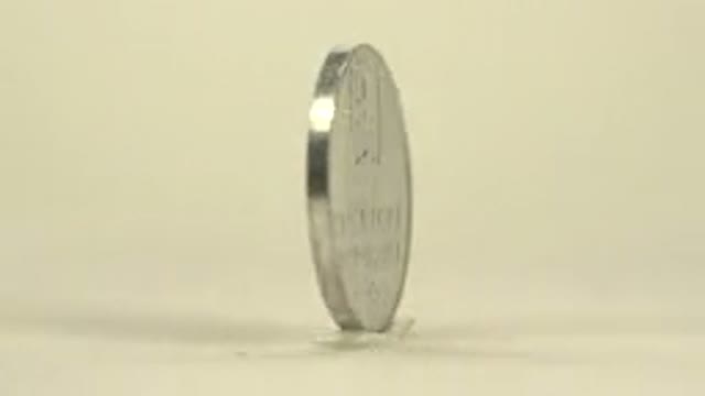 Silver Coin With A Writing On It Slowly Pining On A Cream Background