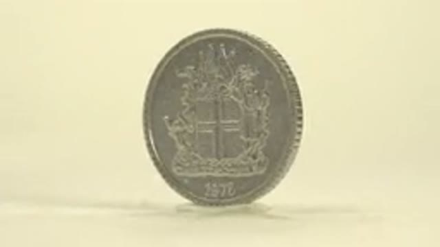 Shiny Silver Coin That Has The Number And The Word Island On It