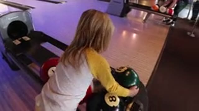 WINTER PARK COLORADO-2019: A Little Girl At A Bowling Alley Picks Up A Ball And Walks Toward The Lane