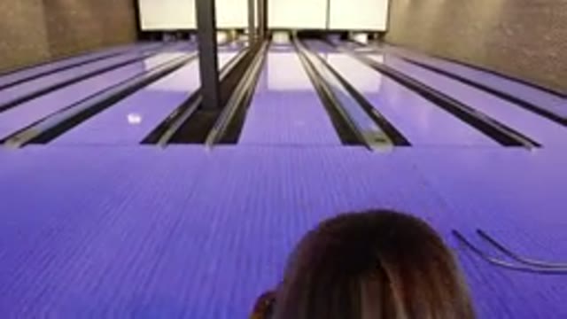 WINTER PARK COLORADO-2019: Little Girl Attempts To Throw The Heavy Ball On A Bowling Rink