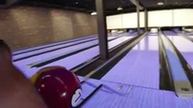 WINTER PARK COLORADO-2019: Little Girl Rolls Red Bowling Ball Through Slide