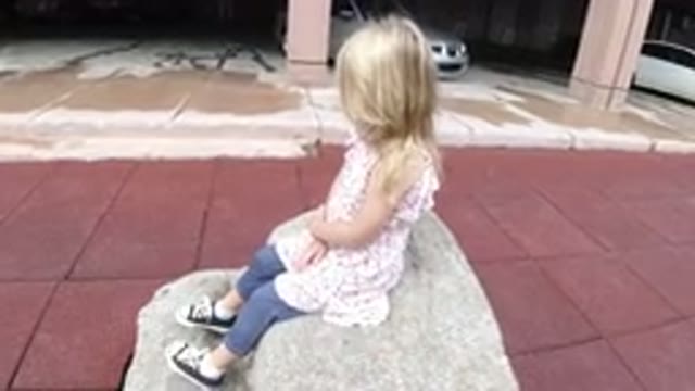 WINTER PARK COLORADO-2019: Girl Sitting On Rock Talking And Pointing At The