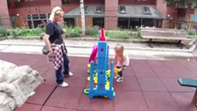 WINTER PARK COLORADO-2019: A Blonde Girl Wearing A Dress And Jeans Plays At A Playground