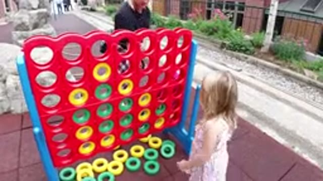 WINTER PARK COLORADO-2019: A Little Girl Playing With Rings Of Various Colors