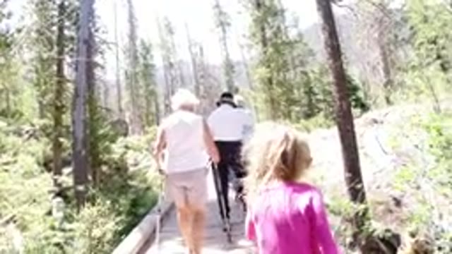 WINTER PARK COLORADO-2019: A Blonde Girl Walking Behind Older People in the Park