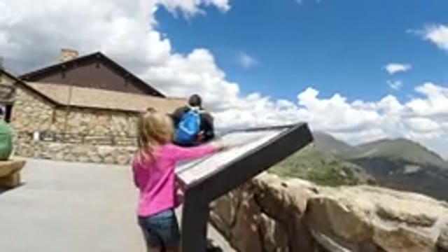 WINTER PARK COLORADO-2019: A Little Girl With Older Adults Admiring A Landmark