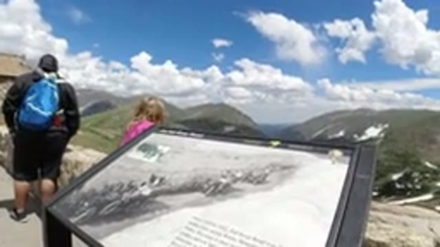 WINTER PARK COLORADO-2019: Child Looking Over Edge Of Overlook With Mountains In