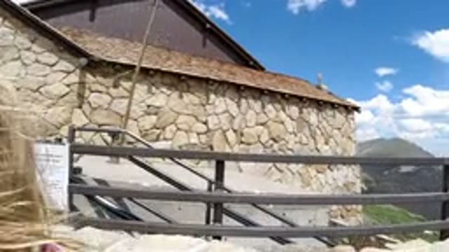 WINTER PARK COLORADO-2019: Blond Girl Passes Between Stone Building and Camera