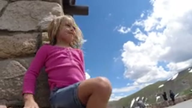 WINTER PARK COLORADO-2019: Little Girl Wearing Pink Shirt Sitting On Rock