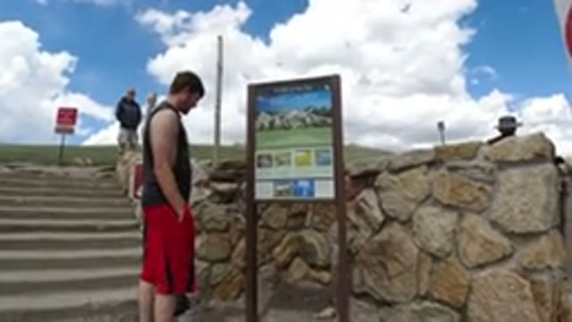 WINTER PARK COLORADO-2019: Young Male Reads A Descriptive Sign By Stone Stairs