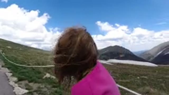WINTER PARK COLORADO-2019: Woman in Pink Dress Walking on Road with Wind