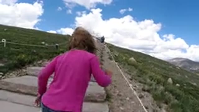 WINTER PARK COLORADO-2019: Little Girl In Pink Shirt Hiking Up A Trail Made Of Grass