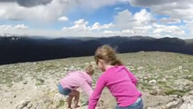 WINTER PARK COLORADO-2019: Two Little Girls Climbing On Rocks On A Sunny Day