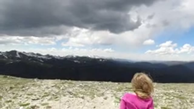 WINTER PARK COLORADO-2019: Young Girl Stands on Top of a Mountain in Windy Weather