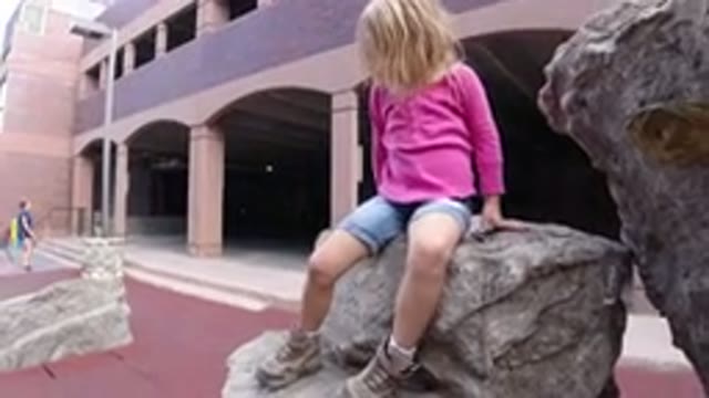 WINTER PARK COLORADO-2019: Little Girl Playing And Climbing A Statue As She
