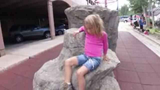 WINTER PARK COLORADO-2019: Child Girl Climbing A Rock To Take Photo In A Park