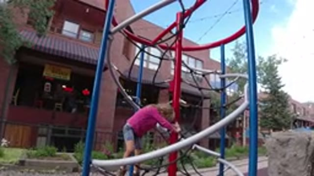 WINTER PARK COLORADO-2019: A Blonde Child Climbing On A Square Toy With Strings